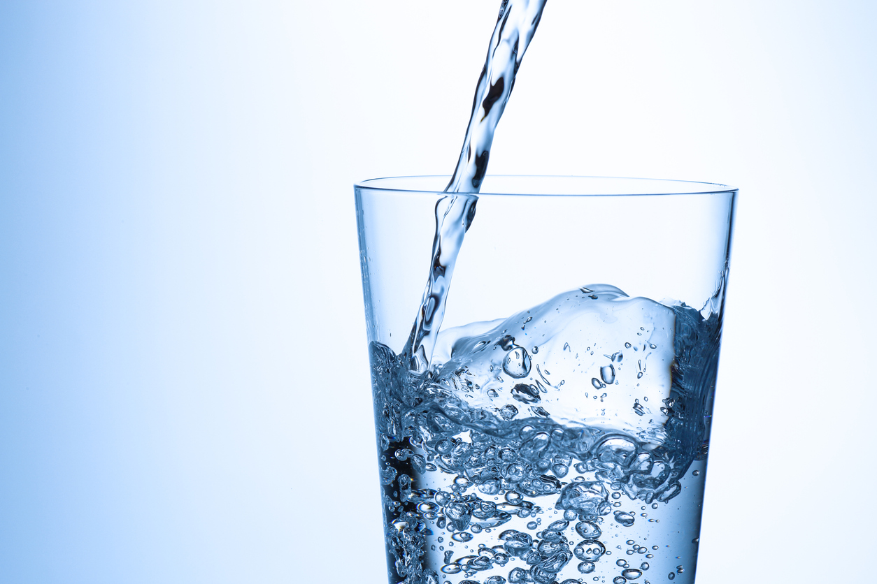 Glass of water being filled after commercial water filter