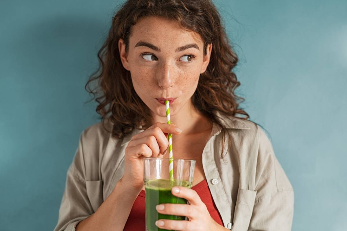 Woman drinking a mix of the healthiest types of juices so green.